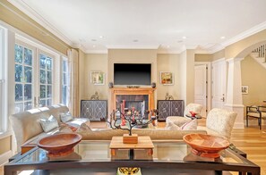 Smart-tv, eldstad, böcker och kontor