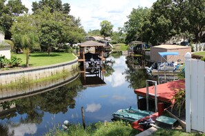 A canal with boats docked, a gazebo, and a covered area with a red roof.