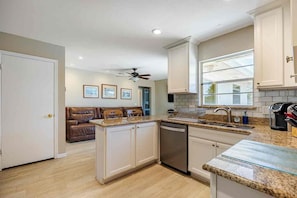 A kitchen with a dishwasher, a sink, and a window.