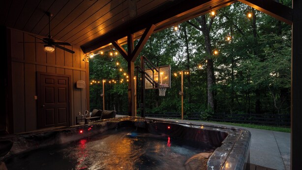 A hot tub area with a basketball hoop and string lights. - Moonlight Retreat - Blue Ridge, Ga. (Blue Ridge)