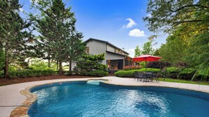 A swimming pool with stone edging, surrounded by a landscaped garden and a building with a satellite dish. - Moonlight Retreat - Blue Ridge, Ga. (Blue Ridge)