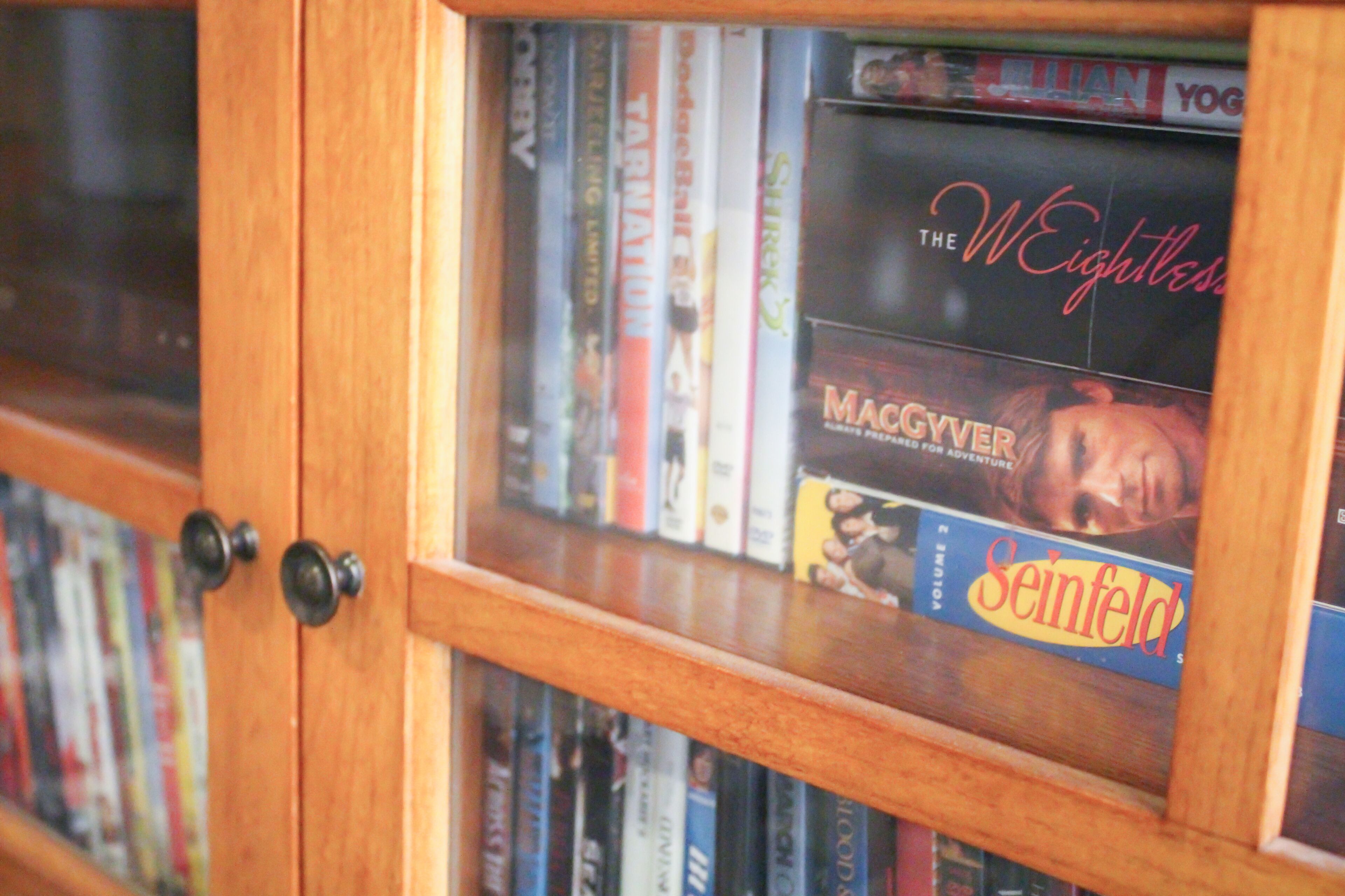 A wooden bookshelf with various books and magazines.