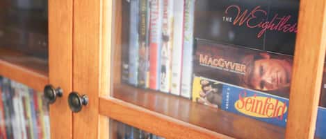 A wooden bookshelf with various books and magazines.