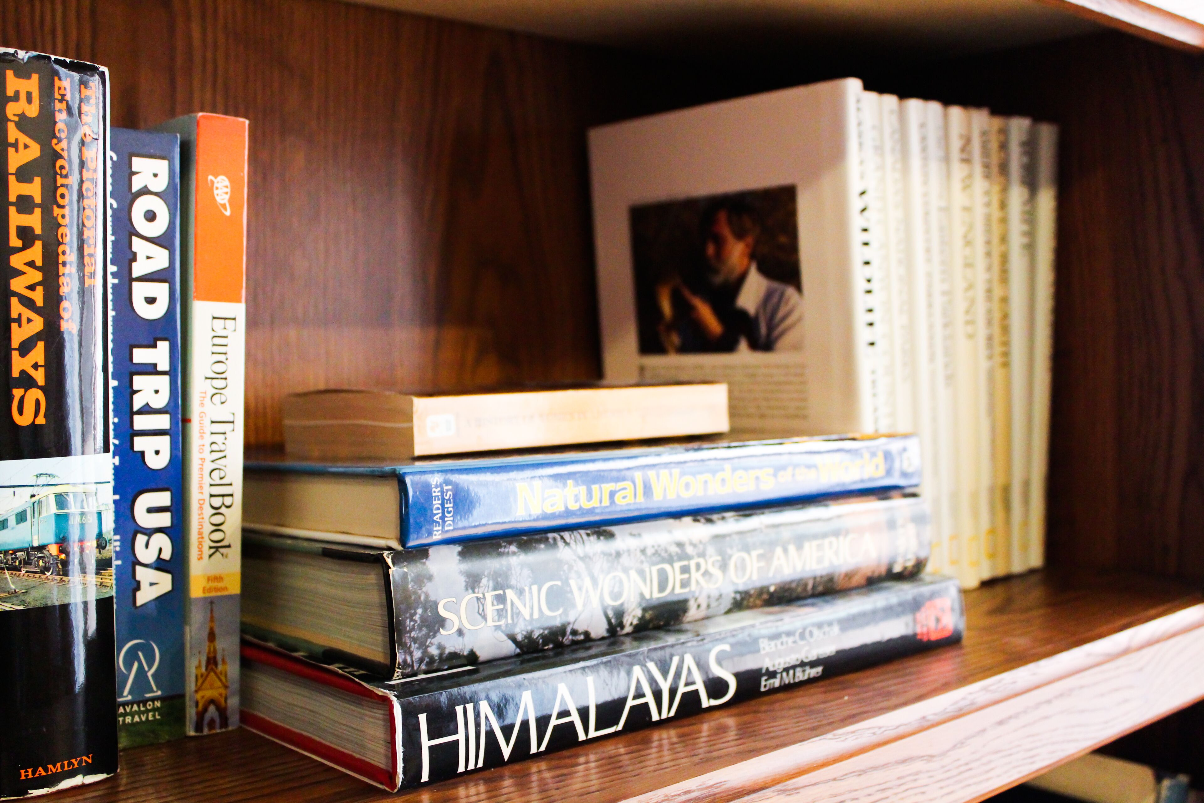 A bookshelf with books on travel topics, including 'Road Trip USA' and 'Himalayas'.