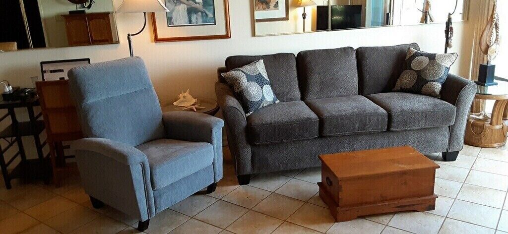 A living room with a grey sofa, a blue armchair, and a wooden coffee table.