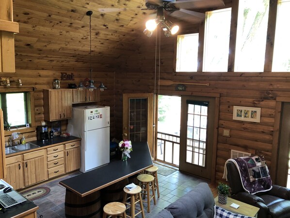 A cozy cabin interior with a kitchen, dining area, and seating space.