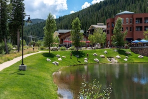 Stroll along the serene lakeside walkway, surrounded by lush greenery and a tranquil pond.