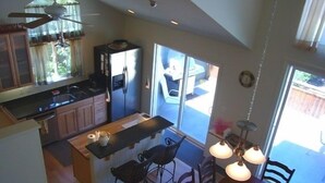 A modern kitchen with a central island, bar stools, and a dining area with a table and chairs. - GREAT LOCATION Private,Spacious+AC -2blk to Town/River/Beach+SPA+Tennis+Kid Park (guerneville)