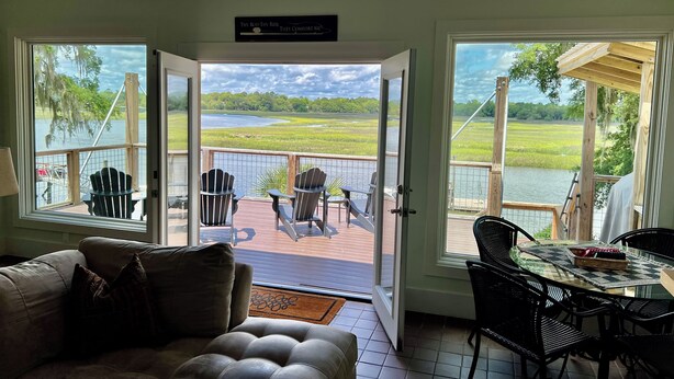 Quarto com vista para um lago, um deck com cadeiras e uma mesa, e um letreiro sobre a porta.