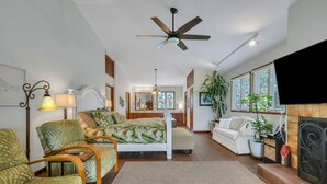 Uma sala de estar ampla com uma cama grande, uma lareira e um espaço para refeições.