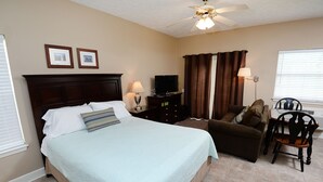 A hotel room with a bed, a TV, a desk, a chair, and curtains. - The Palms Studio, whirlpool, pool (Panama City Beach)