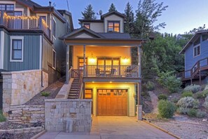 A two-story house with a front porch, a stone retaining wall, and a garage.