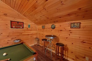 Relax in a warm, inviting space with a pool table, dining area, and personal touches.