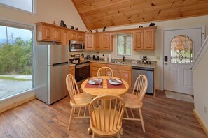 Enjoy meals in this kitchen with a dining table for four and a window offering a view of the outdoors.