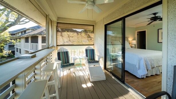 A balcony with wooden flooring, white chairs, and a ceiling fan. - 2BR w/ Marsh Views! Walk to Tennis/Lake House! Amenities included!Pet Friendly! (Seabrook Island)