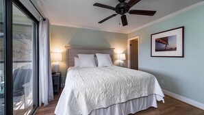 A bedroom with a large bed, a ceiling fan, a nightstand with a lamp, and a framed picture on the wall. - 2BR w/ Marsh Views! Walk to Tennis/Lake House! Amenities included!Pet Friendly! (Seabrook Island)