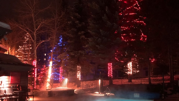 A swimming pool with a hot tub, surrounded by trees and illuminated by red and blue lights. - Lovely Phoenix 2bd. walk to base or take shuttle, pool/hot tub, garage,  ++ (Steamboat Springs)