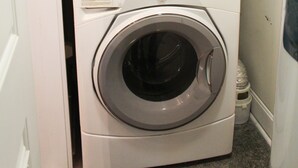 A stacked washer and dryer unit in a laundry room. - Welcome to Derby City Loft! (Louisville)
