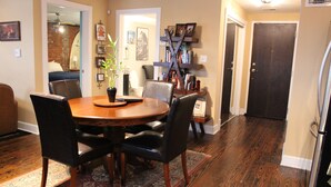 A dining area with a round wooden table, black chairs, and a patterned rug. - Welcome to Derby City Loft! (Louisville)