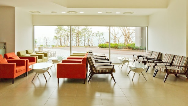 En rummelig lobby med forskellige siddepladser, store vinduer med udsigt til det fri, og et rent, moderne design.