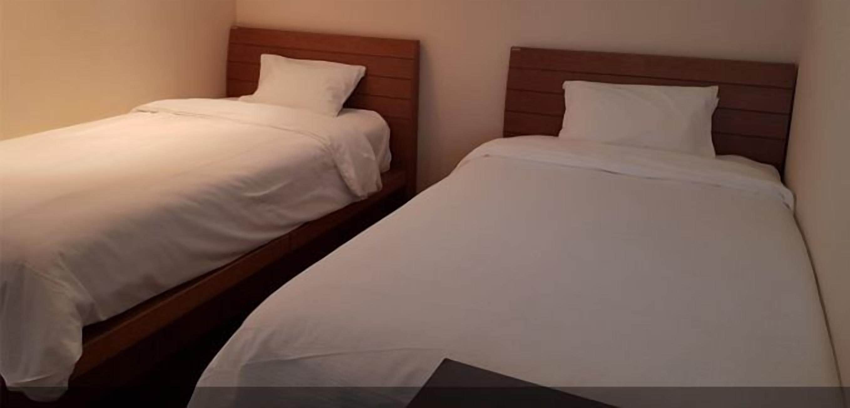 Dos camas individuales con cabeceros de madera en una habitación de hotel.
