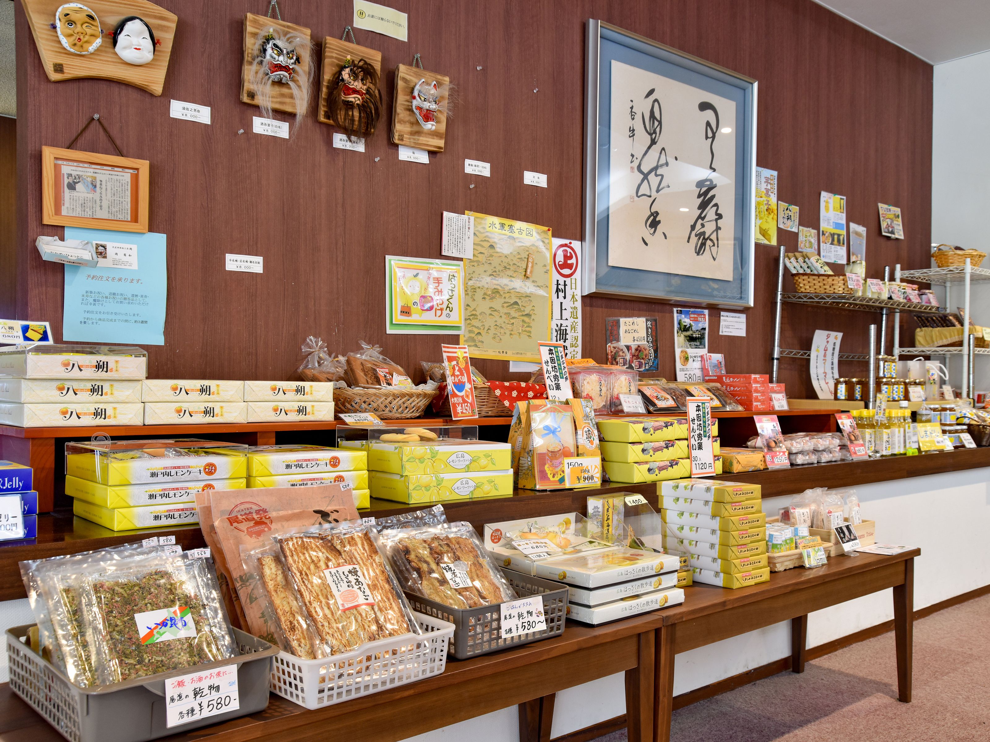 A traditional Japanese shop with various packaged goods, including snacks and dried foods, displayed on wooden shelves and tables.