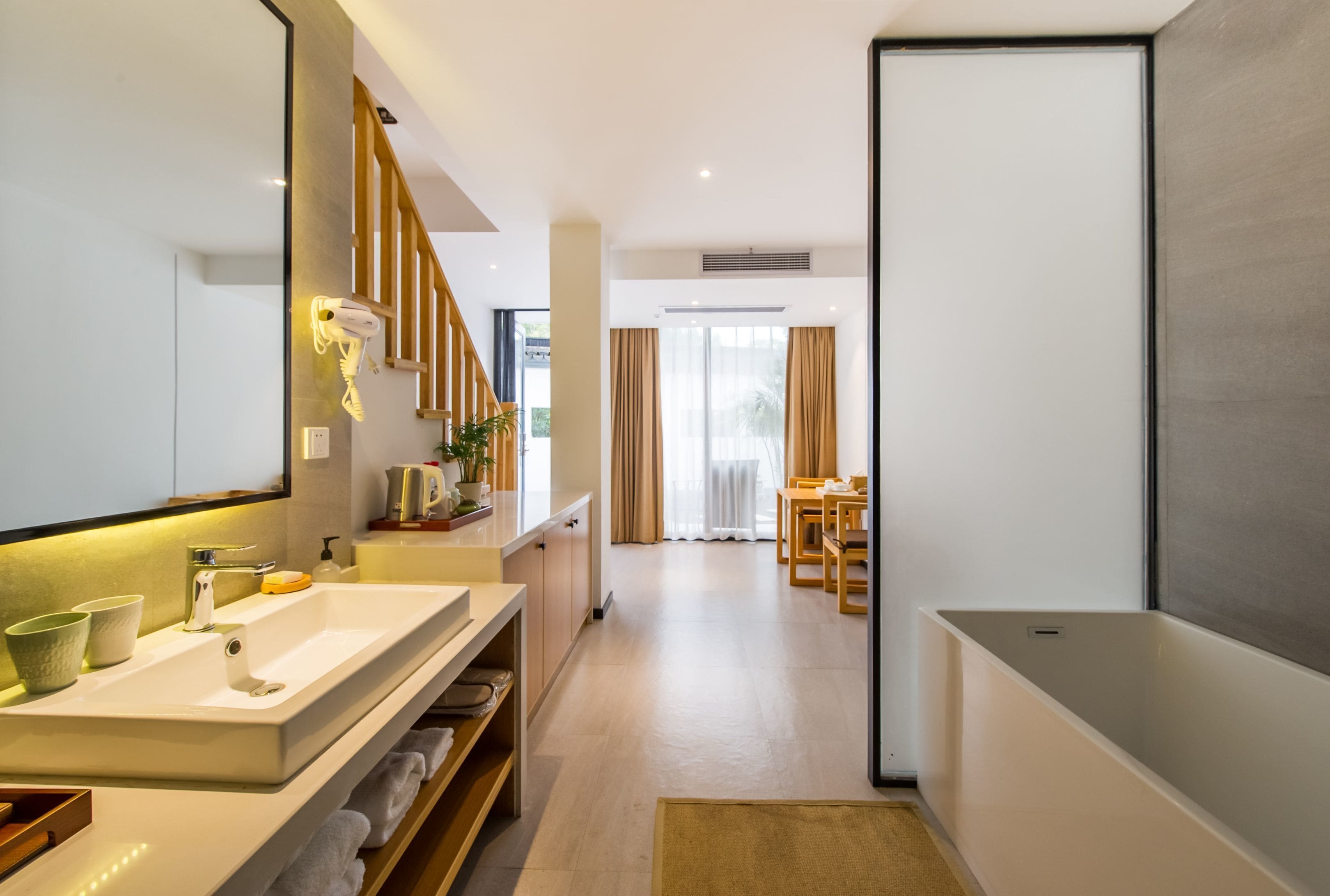 A modern bathroom with a large mirror, a sink, and a shower area.