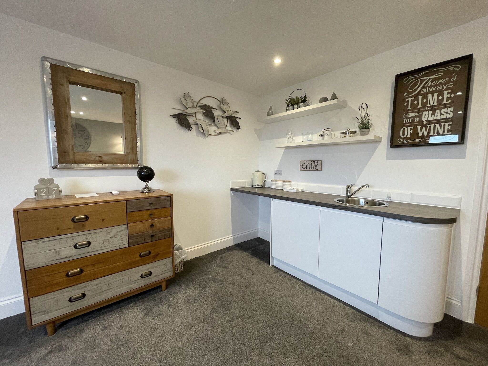 A compact kitchen with a wooden dresser, white cabinets, and a small countertop.