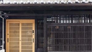 A traditional Japanese gate with a sliding door, a wooden fence, and a tiled roof. - Higashiyama Jin (Kyoto)