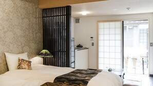 A hotel room with a bed, a nightstand, a lamp, and a sliding door leading to a balcony. - Higashiyama Jin (Kyoto)