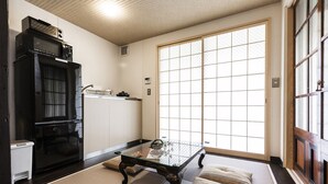 A traditional Japanese-style room with tatami flooring, a low table, and a sliding door with a grid pattern. - Higashiyama Jin (Kyoto)