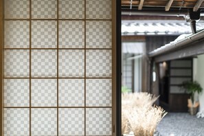 A traditional Japanese room with tatami mat flooring and a shoji screen door. - Higashiyama Jin (Kyoto)