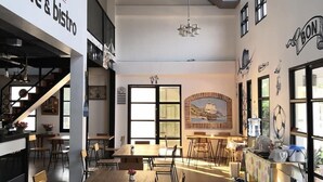 A spacious café & bistro with high ceilings, large windows, and a variety of seating arrangements. - The Lighthouse Resort At Chanthaburi (Chanthaburi)