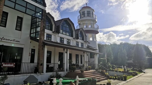 A building with a prominent tower and a large glass facade. - The Lighthouse Resort At Chanthaburi (Chanthaburi)