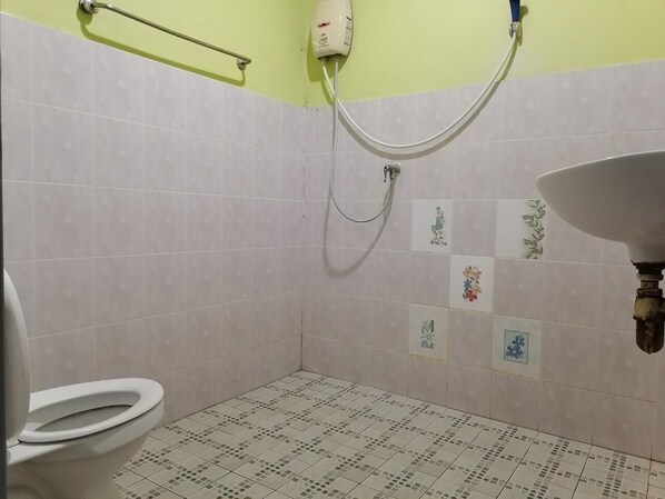 A small bathroom with a toilet, a shower, and a sink.