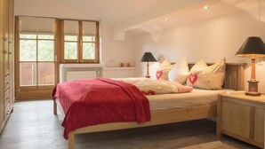 Ein Schlafzimmer mit einem hölzernen Bett, einer roten Decke und zwei Nachttischlampen.