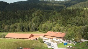 A large building with a sloped roof, surrounded by a parking area and a playground. - holiday flat (Siegsdorf)