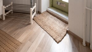 Une chambre avec un lit superposé, un radiateur, une fenêtre avec des rideaux et une petite plante.