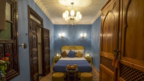 A bedroom with a bed, bedside tables, a chandelier, and a wardrobe. - Riad Ben Tachfine (Marrakech)