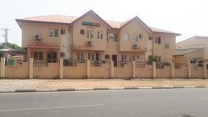 A multi-story building with a sign reading "Avery Hotel." It features multiple windows, a red roof, and a gated entrance. - Avery Hotel (Abuja)