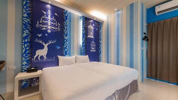 Un dormitorio con cama, mesita de noche y papel tapiz azul y blanco a rayas.
