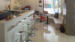 Un café moderne doté d’un bar, de coins salon et offrant une vue sur la rue.