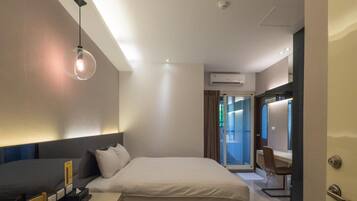 Ein modernes Hotelzimmer mit einem großen Bett, einem Nachttisch und einer Schreibtischzeile.