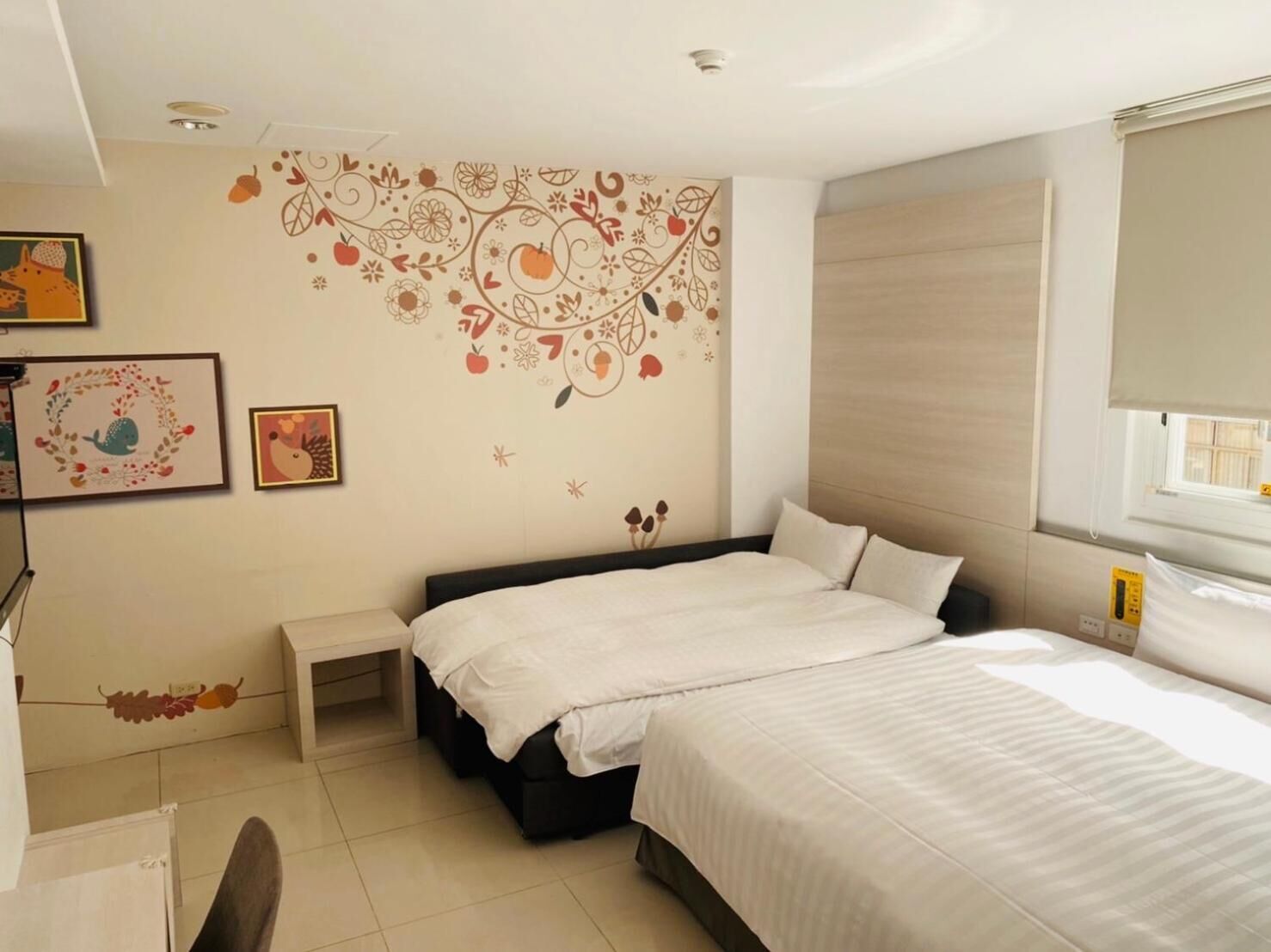 A bedroom with a bed, bedside tables, and a wall with decorative patterns.