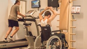 Un gimnasio con cinta de correr y máquina de ejercicios para sillas de ruedas.