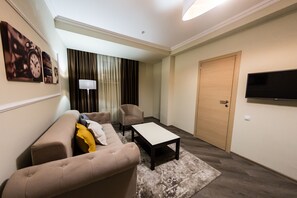 Suite Deluxe | Sala de estar | Televisión de pantalla plana