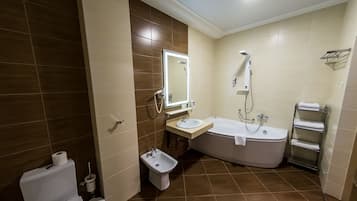 Un baño con inodoro, bidé, lavabo y bañera.