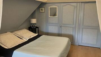 Ein Schlafzimmer mit einem Bett, einem Nachttisch, einer Lampe und einem Kleiderschrank.