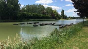 A calm river with a wooden dock extending into the water.