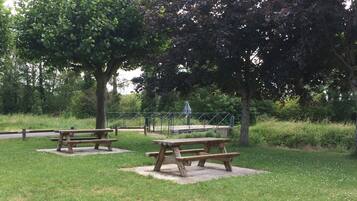 Een park met picknicktafels en een wandelpad.
